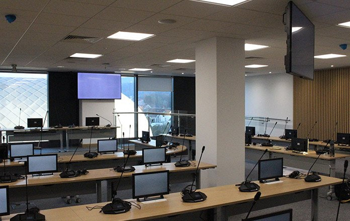 Council chamber with tiered seating and presentation screens  -  The Catalyst