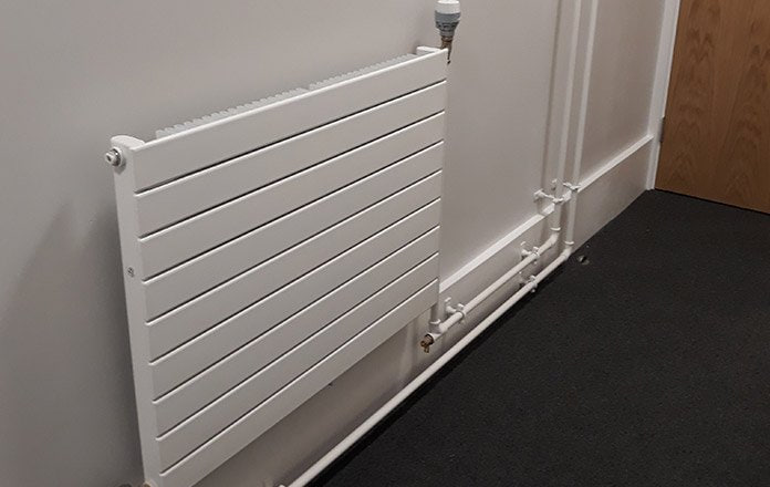 New panel radiator with exposed steel pipework