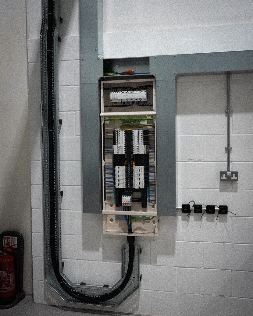Distribution board installed in recessed blockwork enclosure with galvanised trunking  -  commercial unit, Leeds